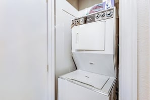A white, wall-mounted, two-door washer and dryer unit with control knobs and a small shelf on top. - 2BR lakefront cabin with private dock (Cle Elum)