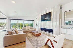 A spacious living room with a large sofa, a coffee table, and a fireplace. - 5 BR Luxury Waterfront Retreat in Gig Harbor (Gig Harbor)