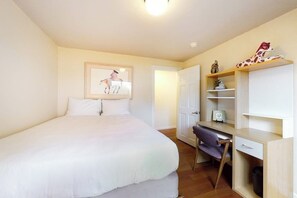 A bedroom with a bed, a desk, and a chair. There is a door leading to another room. - 3BR dog-friendly riverfront home with patio, golf (Renton)