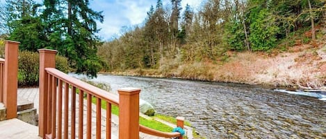 A river with a wooden railing and steps leading down to it.