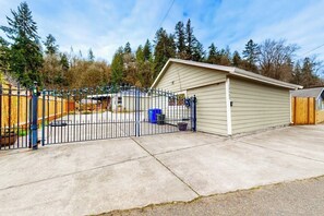 A gated property with a single-story shed, a concrete driveway, and a wooden fence. - 3BR dog-friendly riverfront home with patio, golf (Renton)