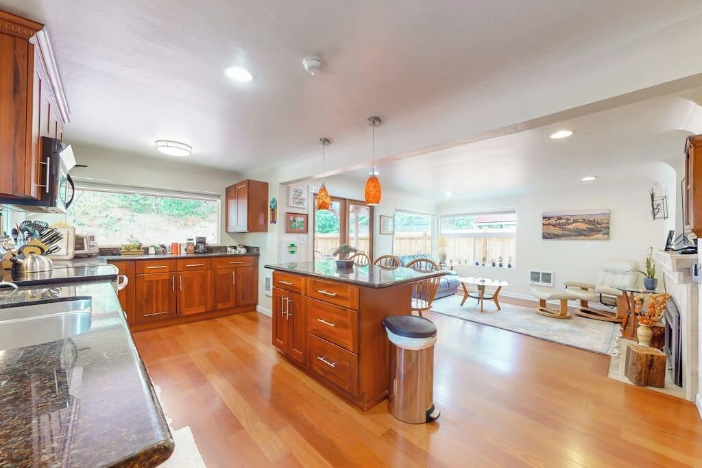 A spacious kitchen with wooden cabinets, a central island, and a dining area with a fireplace.