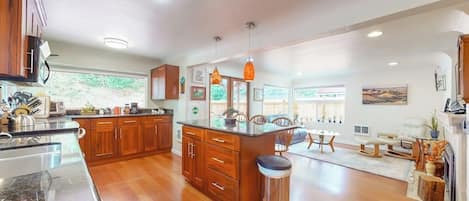 A spacious kitchen with wooden cabinets, a central island, and a dining area with a fireplace.