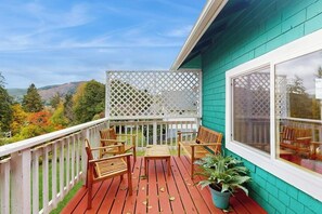 Eine Holzterrasse mit einem weißen Gitter und einem Tisch mit vier Stühlen.