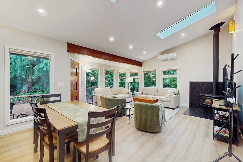 A spacious living area with a dining table, sofas, and a fireplace.