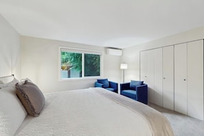 A bedroom with a bed, a window, a wardrobe, and a chair. - 4BR Home with bright open living (Bainbridge Island)