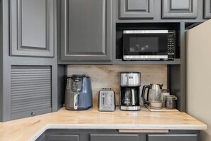 A kitchen with a microwave, coffee maker, toaster, and a kettle on the countertop. - 3BR waterfront home with patio & wildlife watching (Lilliwaup)