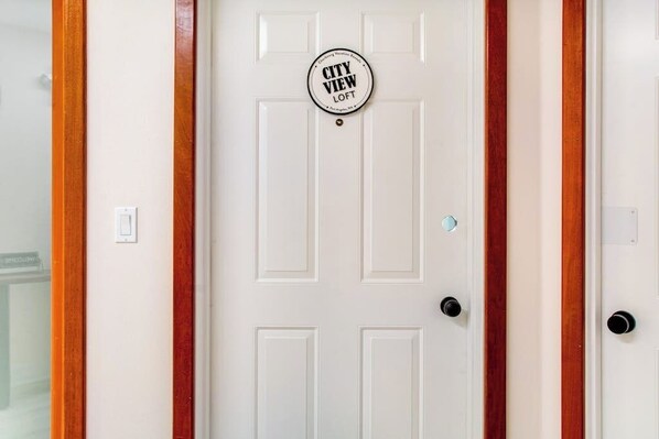 A white door with a circular sign that reads 'CITY VIEW LOFT'.