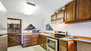 A kitchen with wooden cabinets, a microwave, an oven, and a sink. - 1BR Soundview Dog Friendly - Dock - WoodStove (Shelton)