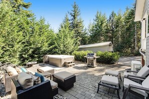 Une terrasse extérieure avec des sièges, un barbecue et un jacuzzi.