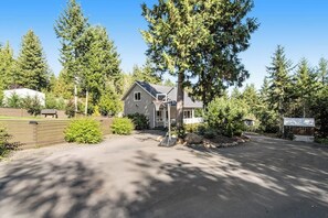 Ein Wohnhaus mit Auffahrt, Basketballkorb und kleiner Werkstatt.