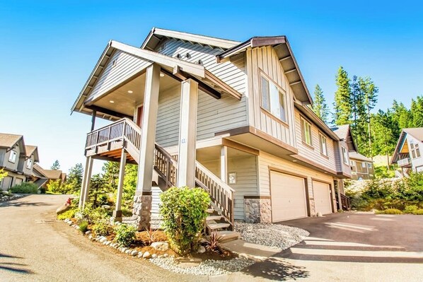 A two-story house with a covered porch, a garage, and a driveway. - 2BR mountainview condo with balcony & pool (Ronald)