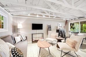 A modern living room with a sofa, armchairs, a coffee table, and a flat-screen TV. - Cabins 1BR Lakefront - Dock - Deck - Firepit (Fall City)