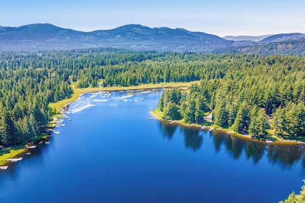 A lake surrounded by dense forest and mountains.