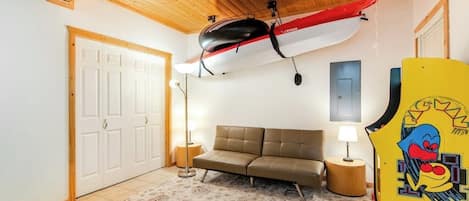 A room with a sofa, a lamp, a door, and a wall-mounted item.
