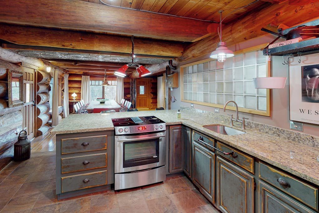 A kitchen with a central island, stainless steel appliances, and a wooden ceiling.