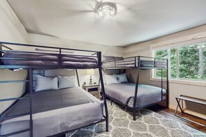 A bunk bed room with a window, a bedside table, and a rug. - 3 BR Cozy Mountain Getaway, New Build (Ronald)
