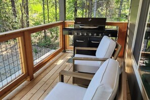 A wooden deck with a grill and seating area. - 3 BR Cozy Mountain Getaway, New Build (Ronald)