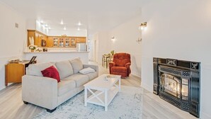 Ein Wohnzimmer mit Sofa, Couchtisch und Kamin.