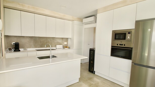 A modern kitchen with white cabinetry, a stainless steel refrigerator, a built-in microwave, and a coffee maker. - Villa Playa de Roche: private pool, 1000m² garden, 2 en suite bathrooms (Roche)