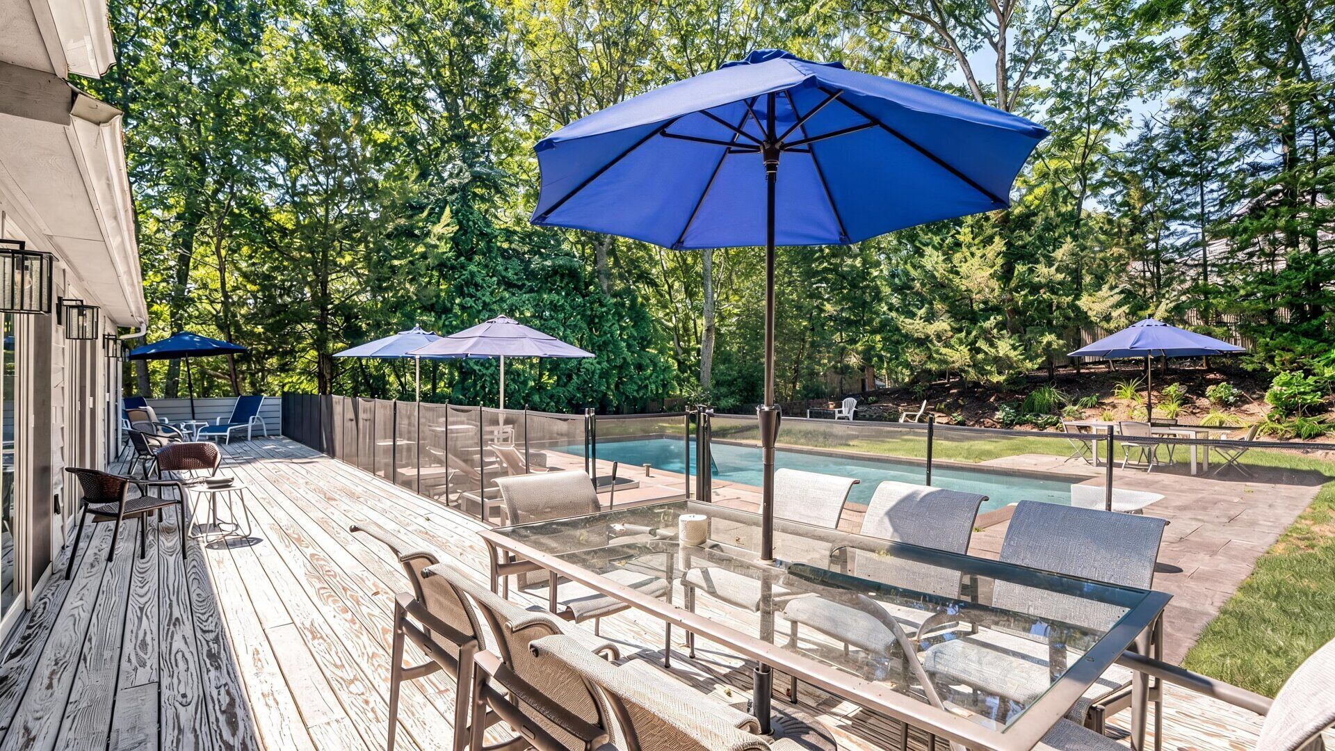 A poolside area with outdoor seating and umbrellas.