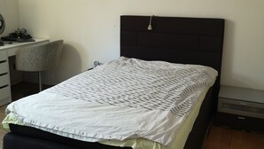 Een slaapkamer met een bed, een bureau en een stoel.