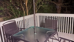 An outdoor patio with a glass table and chairs, surrounded by a white railing. - The Belleville Retreat-Wifi, Quiet Private Patio (Belleville)