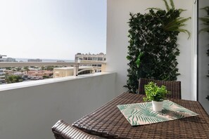 Ein Balkon mit Tisch, Stühlen und einem Blumentopf.