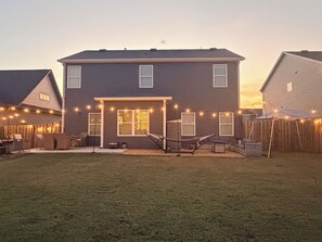 A two-story house with a covered patio area, a hammock, and string lights. - Spacious Home Near UAB Medical West. Quiet Neighborhood, Easy Birmingham Access (Bessemer)