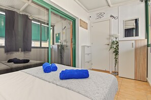 A hotel room with a bed, a wardrobe, a mirror, and a window with curtains. - Spacious and Bright 'Mareverde' Apartment with Sea Views, Pool, and WiFi (Adeje)