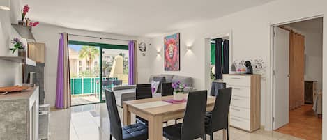 Un espacio habitable moderno con comedor, sofá, cafetera y vistas al exterior.