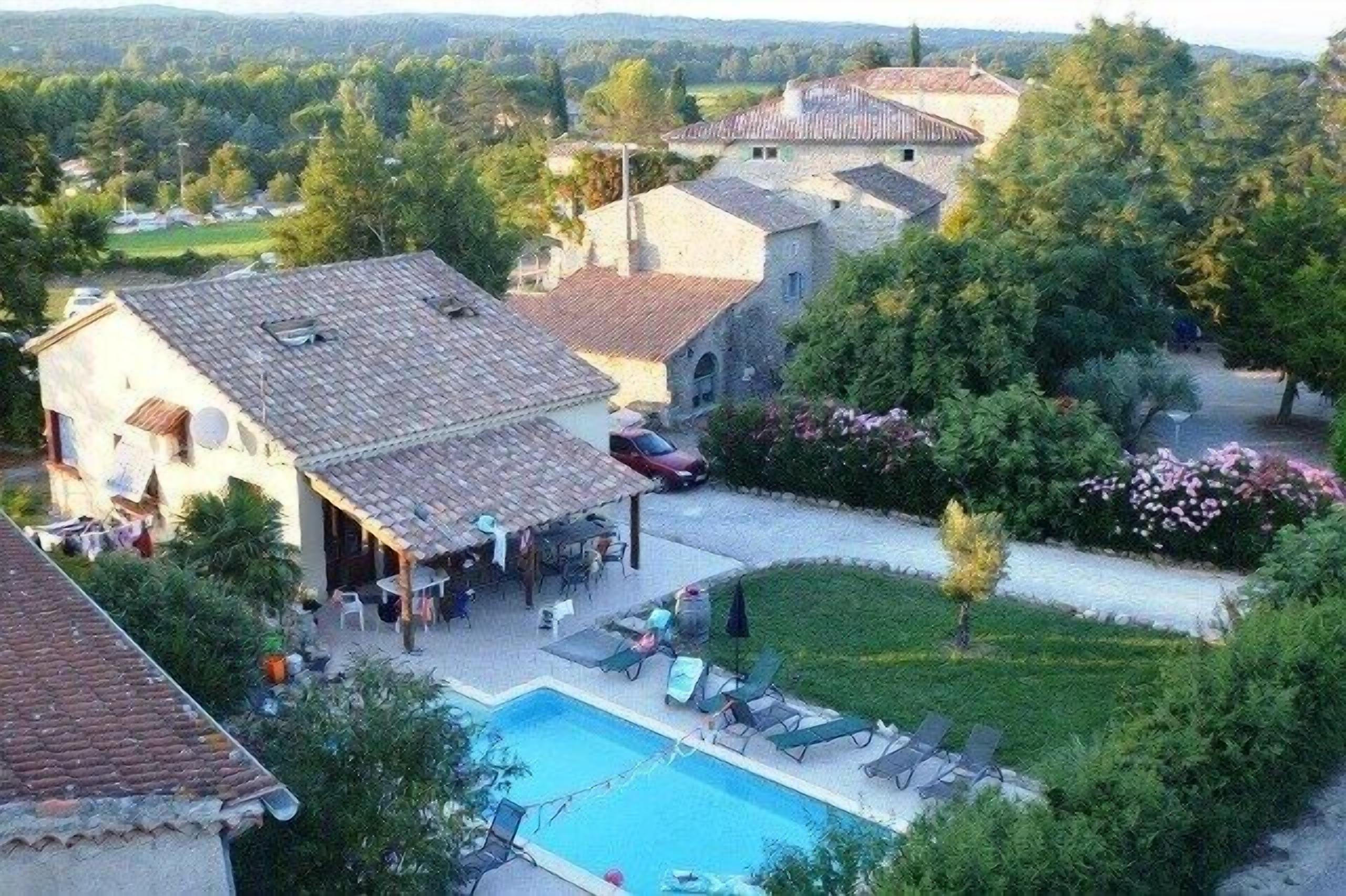 Eine Villa mit Swimmingpool, Außenmöbeln und Garten.