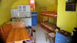 Une pièce compacte avec des lits superposés, une petite kitchenette et un coin repas.