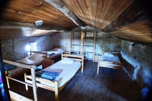 A rustic room with wooden beds and a sloped ceiling. - Vacation Rental #12, Sleeps 12, Domaine de Ribière (Grospierres)