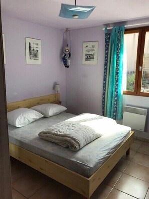 A room with a bed, a window with curtains, and wall-mounted pictures. - "Margaux" Villa, pool, patio, private BBQ, sleeps 8 (Grospierres)