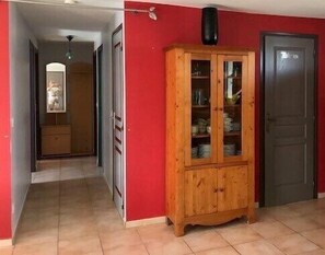 A room with a wooden cabinet, a door, and a hallway leading to another room. - "Margaux" Villa, pool, patio, private BBQ, sleeps 8 (Grospierres)