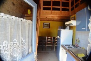 A kitchen with a stove, chairs, and a dining table. - Vacation Rental #11, Terrace & Pool, Domaine de Ribière (Grospierres)