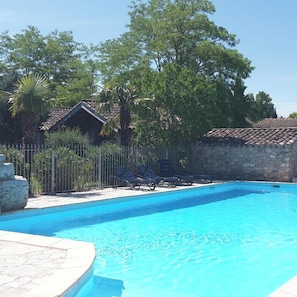 Ein Pool mit Liegestühlen und einer Steinmauer.
