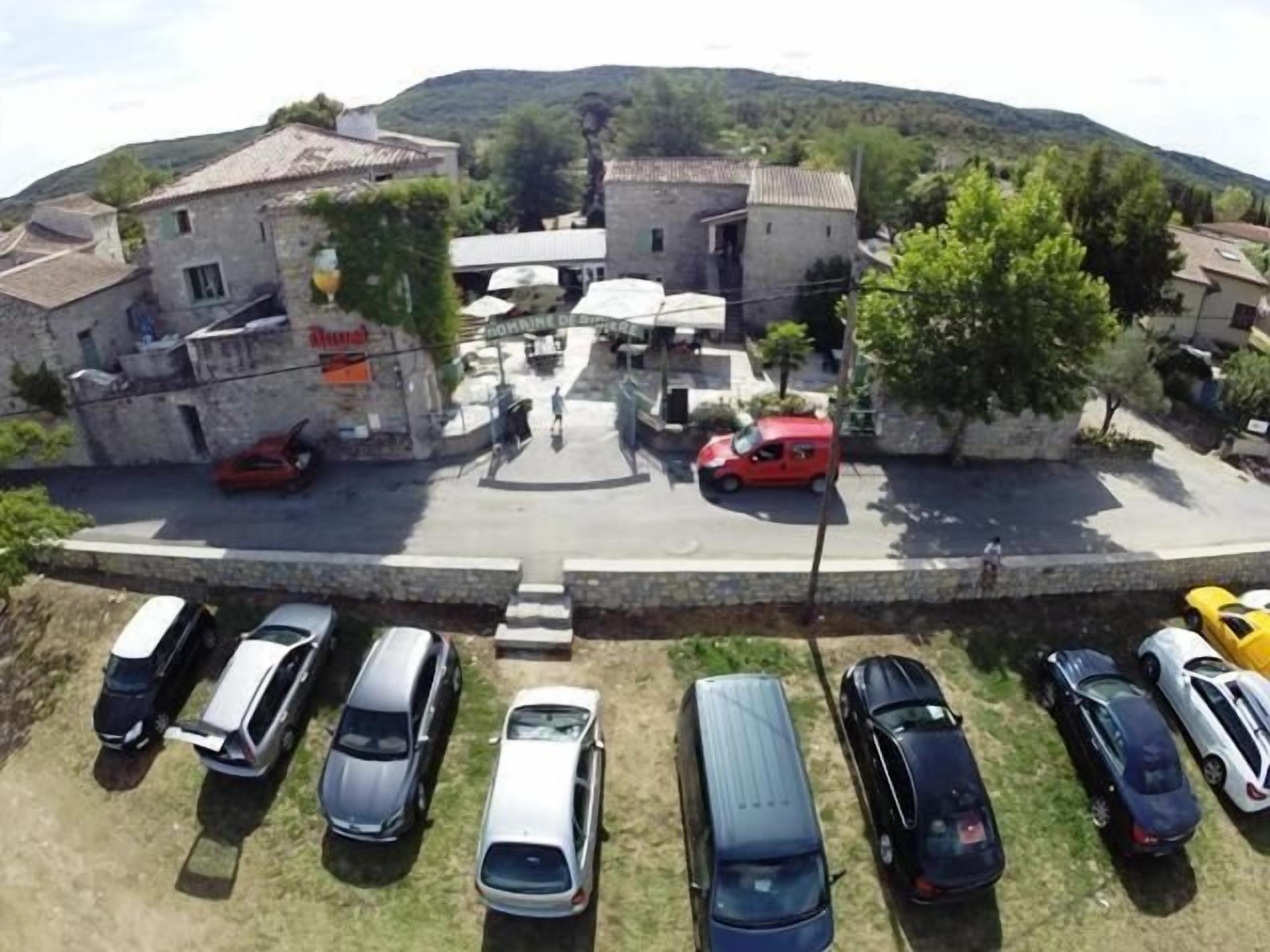 Un espace de stationnement avec plusieurs voitures et un bâtiment portant une enseigne.