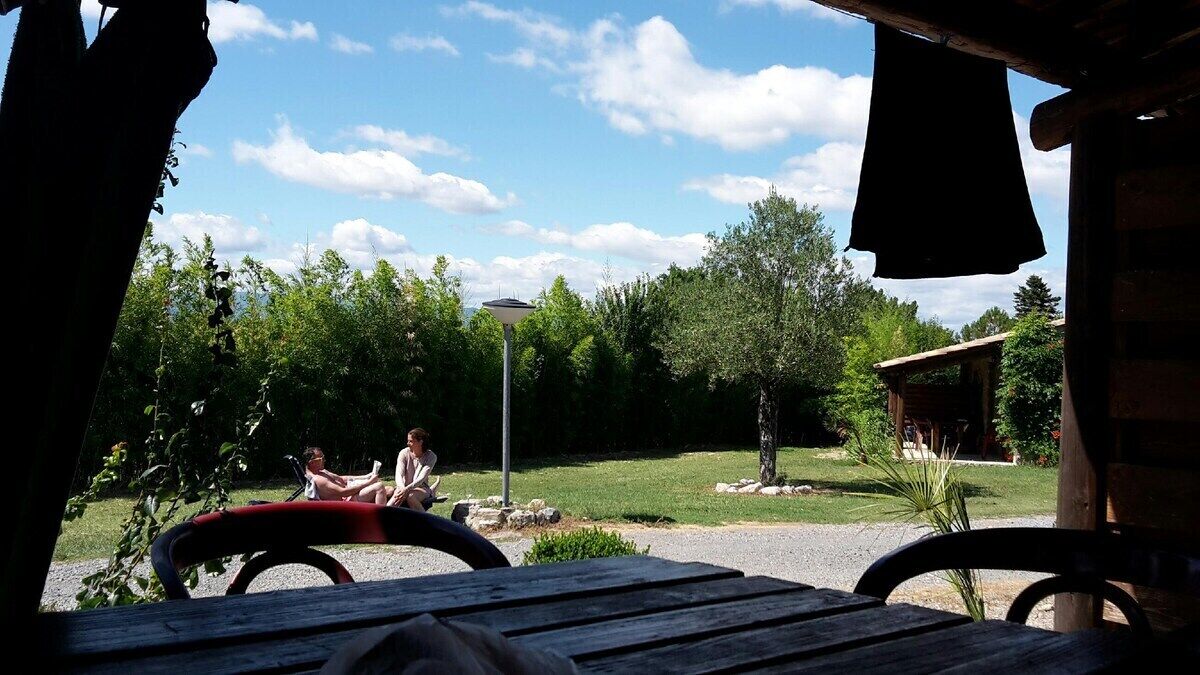 An outdoor seating area with a view of a grassy landscape and trees.