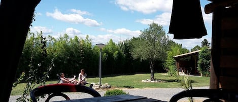 Un área de estar al aire libre con vistas a un paisaje con césped y árboles.
