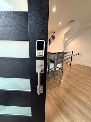 A modern interior with a black door featuring a keypad lock and a handle. - Beach Haus~Modern Comfort Spacious 4-bedroom in Pacific Beach/La Jolla (San Diego)