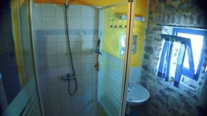 A bathroom with a shower, toilet, and a window. - Vrbo Property (Grospierres)