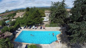 A rectangular swimming pool surrounded by lounge chairs and a stone deck. - Vrbo Property (Grospierres)