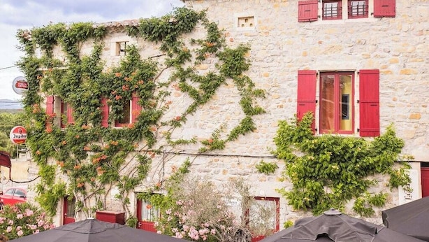 A stone building with red shutters and ivy growth. - Vrbo Property (Grospierres)