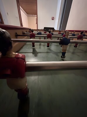 A room with a large mirror reflecting a person in a red shirt.