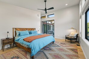 A bedroom with a bed, a nightstand, a chair, a window, and a ceiling fan. - Blazing Elephant - Stunning VIEWS, Pet Friendly, Central Location (Sedona)