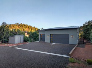 A modern two-story building with a garage, a small utility shed, and a driveway. - Blazing Elephant - Stunning VIEWS, Pet Friendly, Central Location (Sedona)
