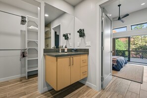 A modern bathroom with a wooden vanity, a large mirror, and a view of the outdoors. - Blazing Elephant - Stunning VIEWS, Pet Friendly, Central Location (Sedona)