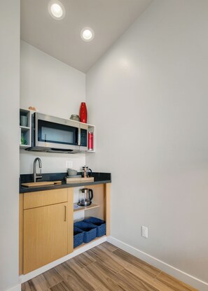 A compact kitchen with a microwave, coffee maker, and storage shelves. - Blazing Elephant - Stunning VIEWS, Pet Friendly, Central Location (Sedona)